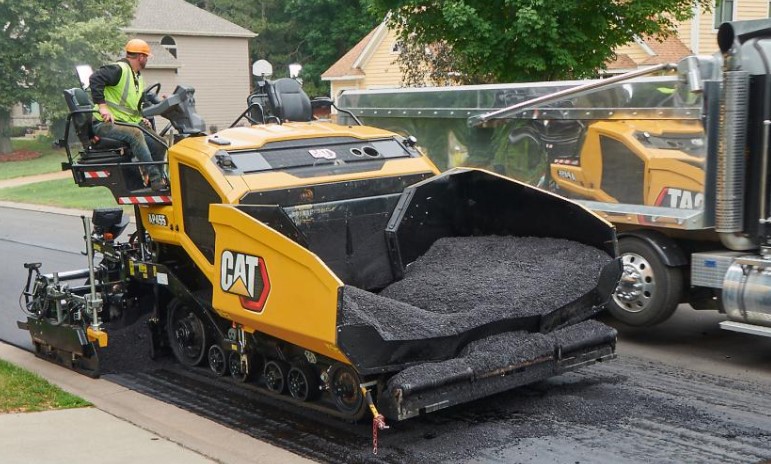 Truck and paving machine in operation