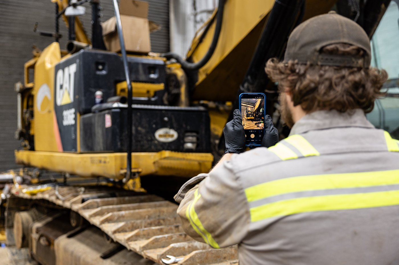Technician photographing equipment to document service progress and share updates with the customer.