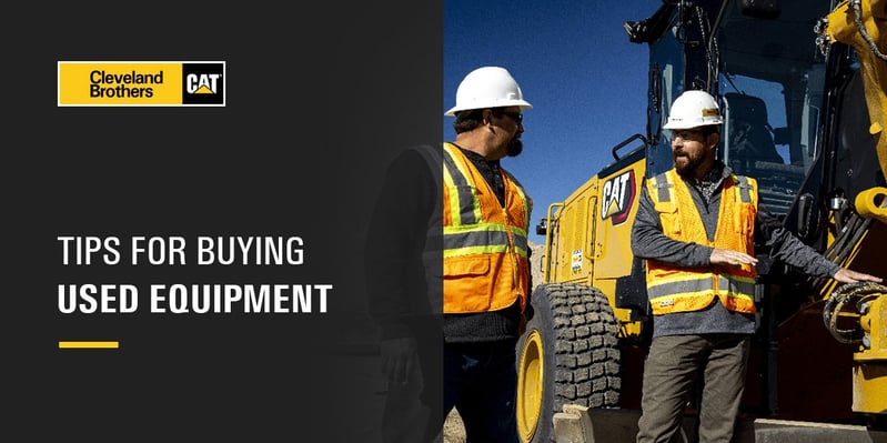 Construction workers beside equipment