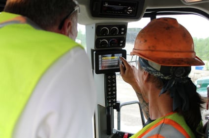 Employee examining wheel-loader digital monitor