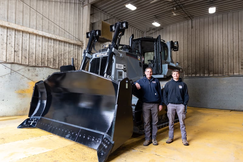 Customer and son stand with newly rebuilt D8T at Cleveland Brothers Somerset Branch