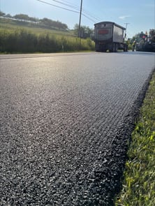 Fresh asphalt paved by Derry Construction using the Cat SDX Screed Plate System.